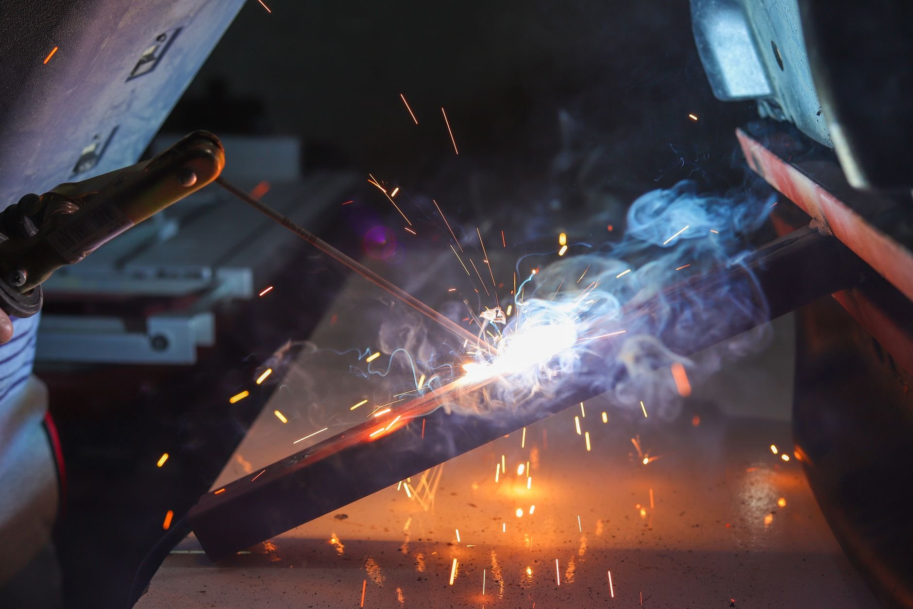Welder at work with sparks in an industrial setting