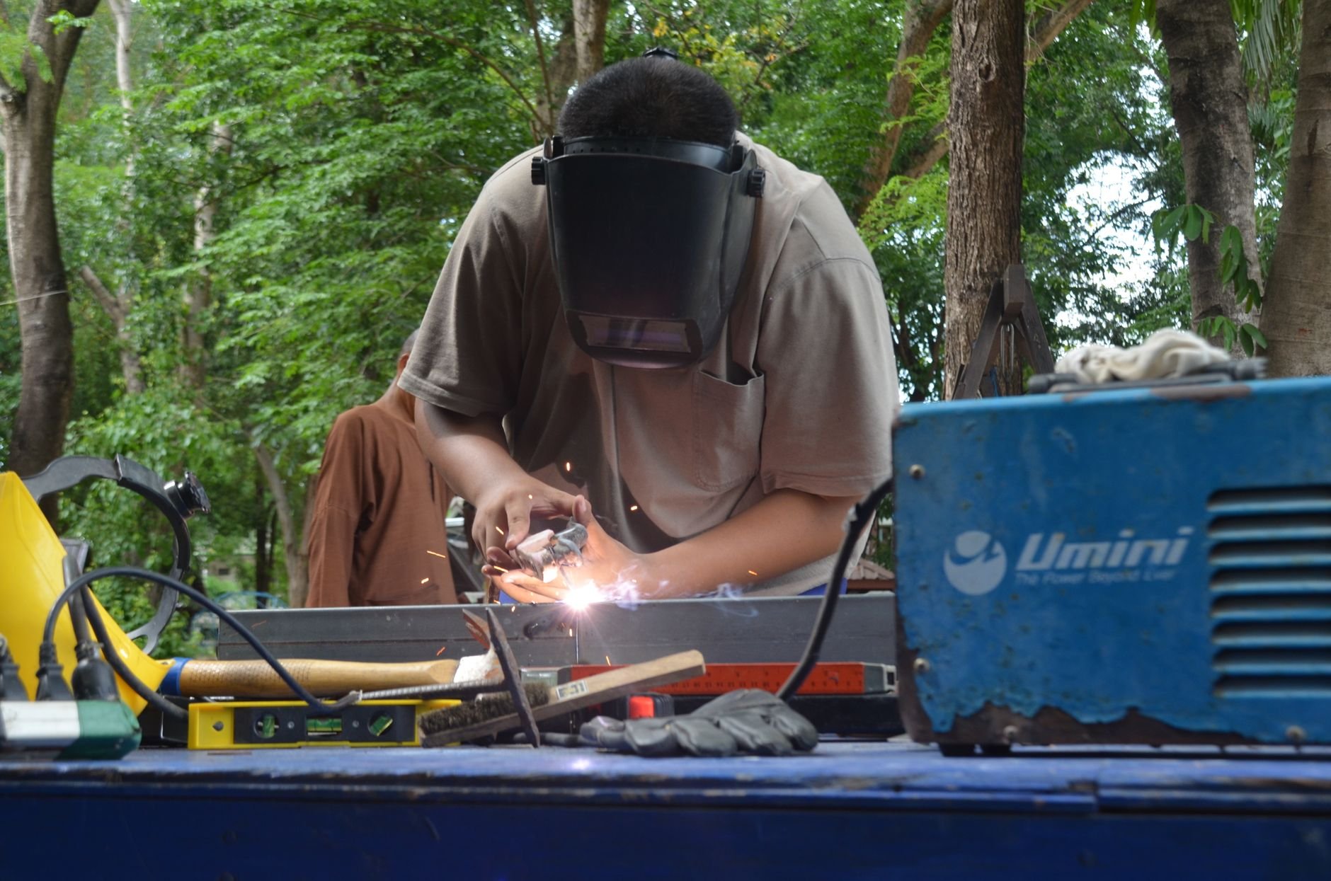 Skilled tradesman welding outdoors with tools